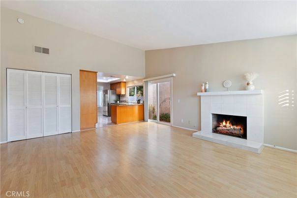 Empty room, Fireplace, Interior, Kitchen, Recessed Lighting, Stainless Steel Appliances, Wood Texture Flooring