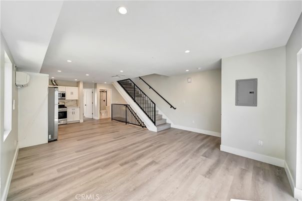 Empty room, Interior, Kitchen, Recessed Lighting, Stainless Steel Appliances, Wood Texture Flooring