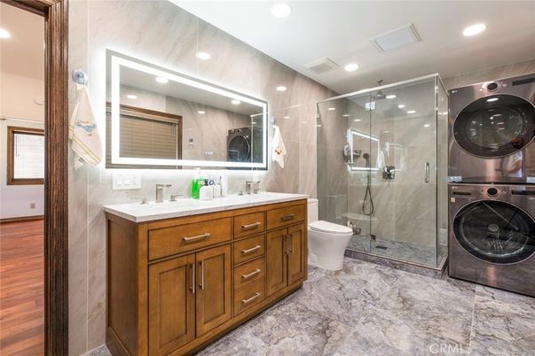 Bathroom, Dual Sink Vanities, Glass Shower, Interior, Recessed Lighting, Washer, Wood Texture Flooring