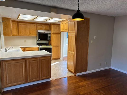 Interior, Kitchen, Pendant Lights, Stainless Steel Appliances, Tile Countertops, Wood Texture Flooring