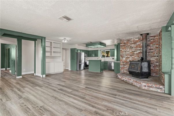 Empty room, Fireplace, Interior, Kitchen, Stainless Steel Appliances, Stone Walls, Wood Texture Flooring
