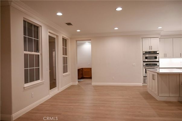 Empty room, Interior, Kitchen, Recessed Lighting, Stainless Steel Appliances, Wood Texture Flooring