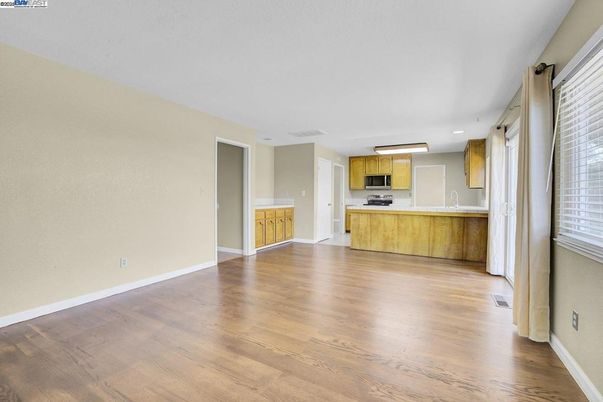 Empty room, Interior, Kitchen, Recessed Lighting, Stainless Steel Appliances, Wood Texture Flooring
