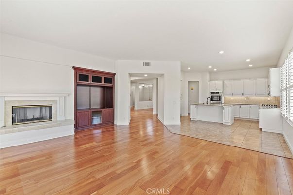 Empty room, Fireplace, Interior, Kitchen, Recessed Lighting, Stainless Steel Appliances, Wood Texture Flooring