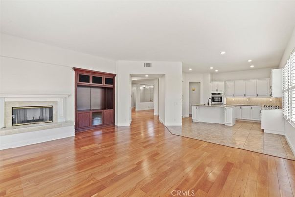 Empty room, Fireplace, Interior, Kitchen, Recessed Lighting, Stainless Steel Appliances, Wood Texture Flooring