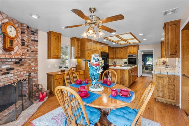 Dining room, Fireplace, Interior, Kitchen, Recessed Lighting, Stone Walls, Tile Countertops, Wood Texture Flooring