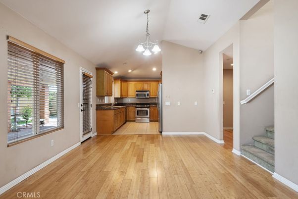 Empty room, Interior, Kitchen, Pendant Lights, Recessed Lighting, Stainless Steel Appliances, Wood Texture Flooring