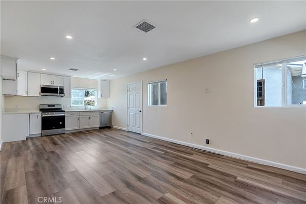 Empty room, Interior, Kitchen, Recessed Lighting, Stainless Steel Appliances, Wood Texture Flooring