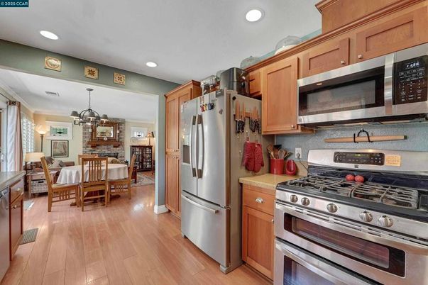 Chandelier, Dining room, Fireplace, Interior, Kitchen, Pendant Lights, Recessed Lighting, Stainless Steel Appliances, Stone Walls, Wood Texture Flooring