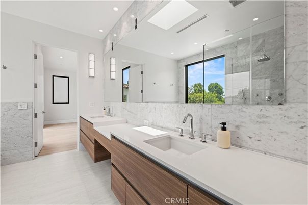 Bathroom, Dual Sink Vanities, Glass Shower, Interior, Marble Walls, Recessed Lighting, Wood Texture Flooring