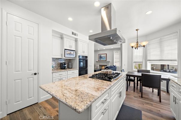 Chandelier, Dining room, Fireplace, Interior, Kitchen, Pendant Lights, Recessed Lighting, Stainless Steel Appliances, Wood Texture Flooring