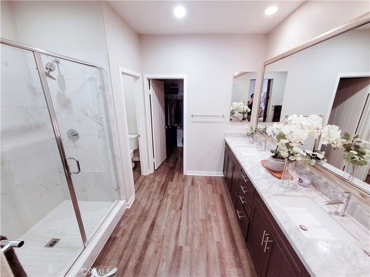 Bathroom, Dual Sink Vanities, Glass Shower, Interior, Marble Walls, Recessed Lighting, Wood Texture Flooring
