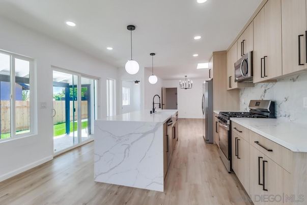 Chandelier, Interior, Kitchen, Marble Walls, Pendant Lights, Recessed Lighting, Stainless Steel Appliances, Wood Texture Flooring
