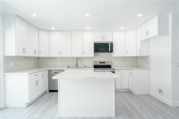 Interior, Kitchen, Marble Walls, Recessed Lighting, Stainless Steel Appliances, Wood Texture Flooring