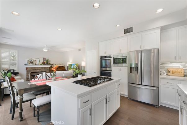 Dining room, Fireplace, Interior, Kitchen, Living room, Recessed Lighting, Stainless Steel Appliances, Wood Texture Flooring