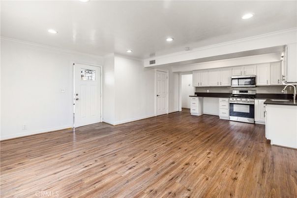 Empty room, Interior, Kitchen, Recessed Lighting, Stainless Steel Appliances, Wood Texture Flooring