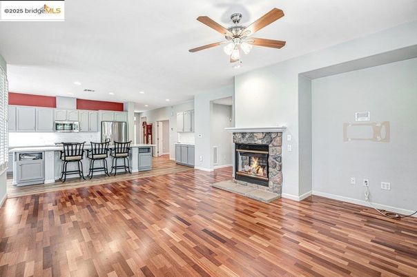Empty room, Fireplace, Interior, Kitchen, Recessed Lighting, Stainless Steel Appliances, Wood Texture Flooring