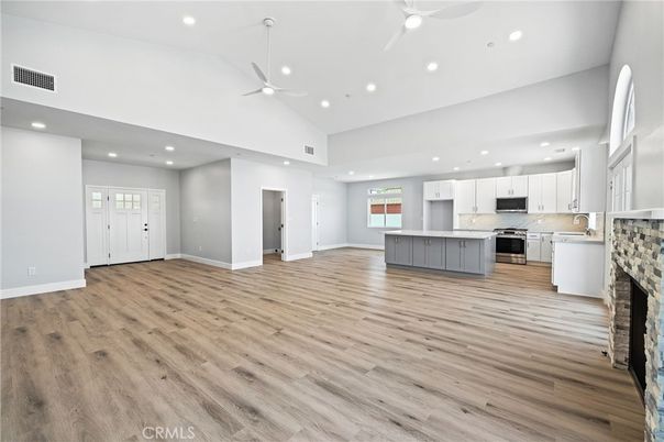 Empty room, Fireplace, Interior, Kitchen, Recessed Lighting, Stainless Steel Appliances, Wood Texture Flooring