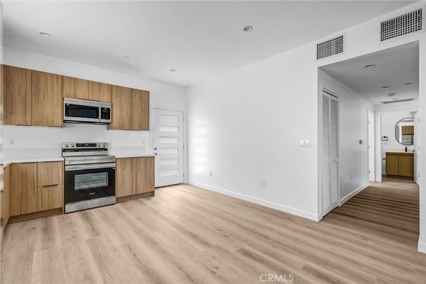Empty room, Interior, Kitchen, Recessed Lighting, Stainless Steel Appliances, Wood Texture Flooring