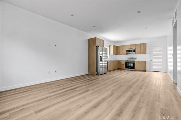 Empty room, Interior, Kitchen, Recessed Lighting, Stainless Steel Appliances, Wood Texture Flooring