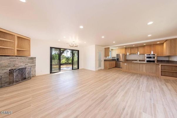 Empty room, Fireplace, Interior, Kitchen, Recessed Lighting, Stainless Steel Appliances, Wood Texture Flooring