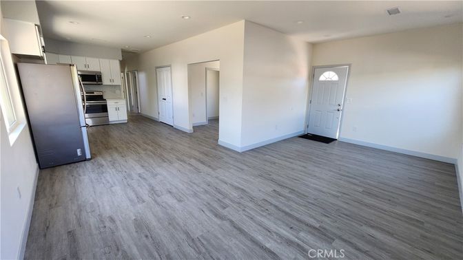 Empty room, Interior, Kitchen, Recessed Lighting, Stainless Steel Appliances, Wood Texture Flooring