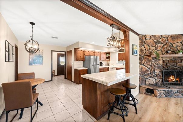 Chandelier, Dining room, Fireplace, Interior, Kitchen, Pendant Lights, Stone Walls, Tile Countertops