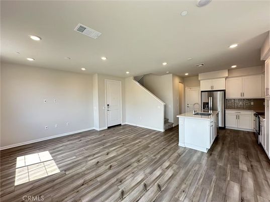 Empty room, Interior, Kitchen, Recessed Lighting, Stainless Steel Appliances, Wood Texture Flooring