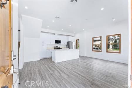Empty room, Interior, Kitchen, Recessed Lighting, Stainless Steel Appliances, Wood Texture Flooring
