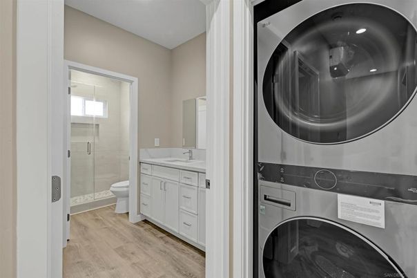 Bathroom, Glass Shower, Interior, Recessed Lighting, Washer, Wood Texture Flooring