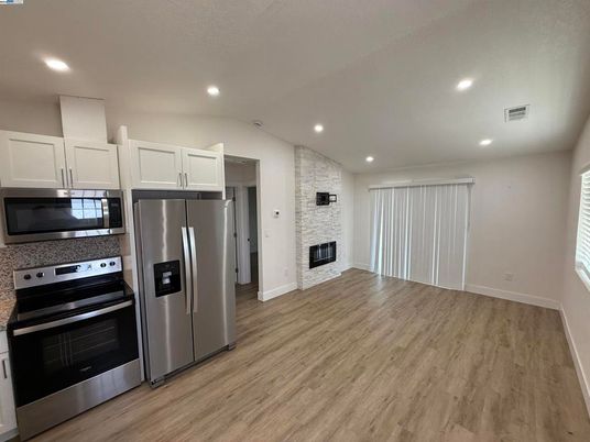 Fireplace, Interior, Kitchen, Recessed Lighting, Stainless Steel Appliances, Wood Texture Flooring