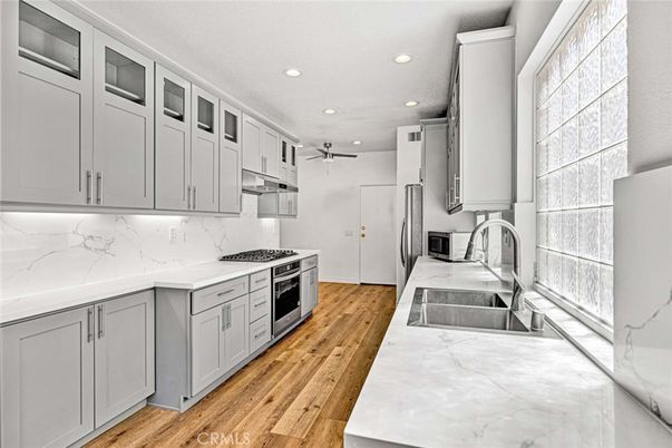 Interior, Kitchen, Marble Walls, Recessed Lighting, Stainless Steel Appliances, Wood Texture Flooring
