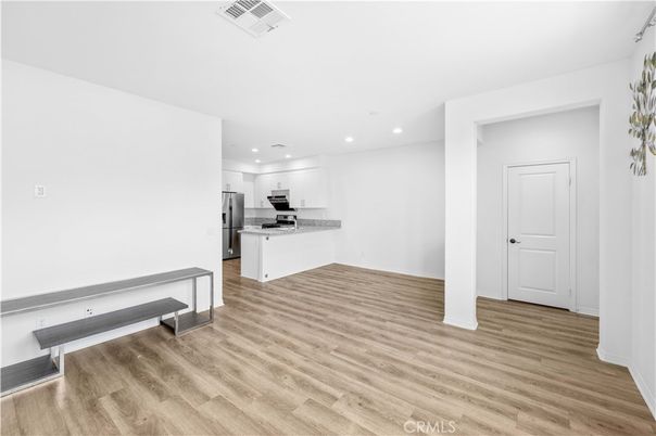 Empty room, Interior, Kitchen, Recessed Lighting, Stainless Steel Appliances, Wood Texture Flooring