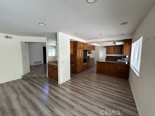 Empty room, Interior, Kitchen, Recessed Lighting, Stainless Steel Appliances, Wood Texture Flooring
