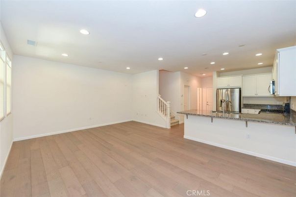 Empty room, Interior, Kitchen, Recessed Lighting, Stainless Steel Appliances, Wood Texture Flooring