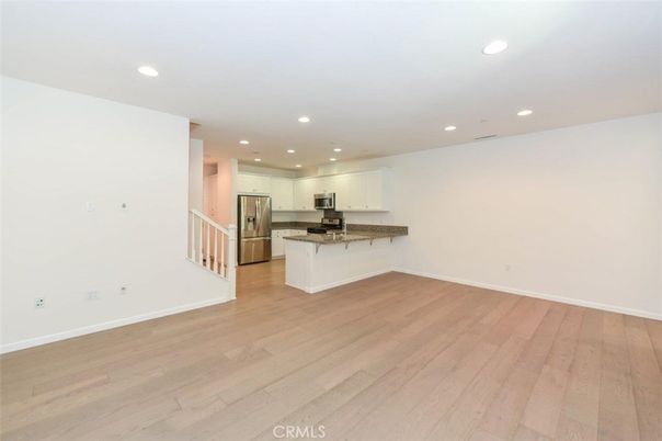 Empty room, Interior, Kitchen, Recessed Lighting, Stainless Steel Appliances, Wood Texture Flooring