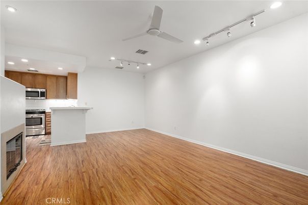 Empty room, Interior, Kitchen, Recessed Lighting, Stainless Steel Appliances, Wood Texture Flooring