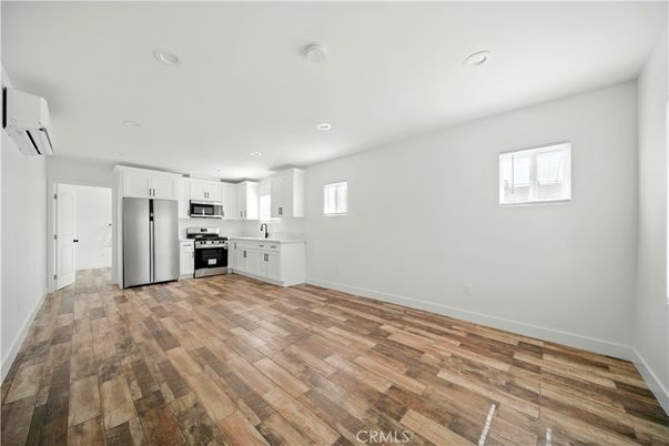 Empty room, Interior, Kitchen, Recessed Lighting, Stainless Steel Appliances, Wood Texture Flooring