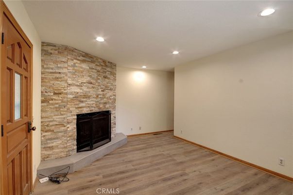 Empty room, Fireplace, Interior, Recessed Lighting, Stone Walls, Wood Texture Flooring