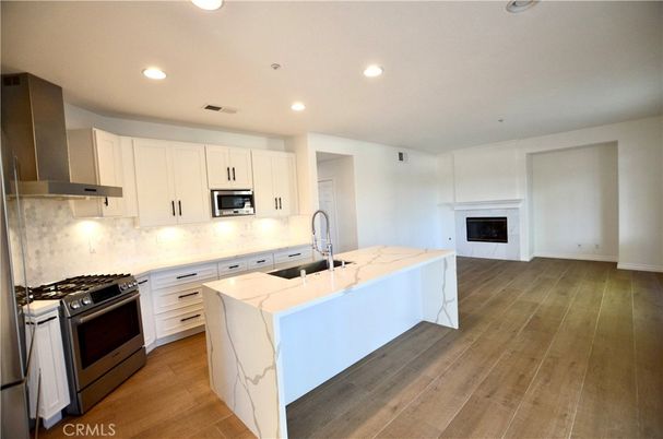 Fireplace, Interior, Kitchen, Recessed Lighting, Stainless Steel Appliances, Wood Texture Flooring