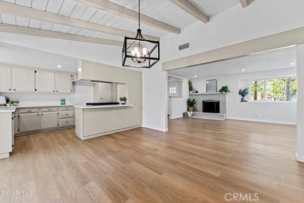 Empty room, Fireplace, Interior, Kitchen, Pendant Lights, Recessed Lighting, Stainless Steel Appliances, Wooden Beams, Wood Texture Flooring