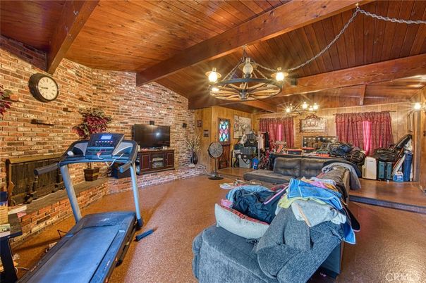 Chandelier, Fireplace, Fitness Equipment, Interior, Living room, Stone Walls, Wooden Beams, Wooden Ceilings