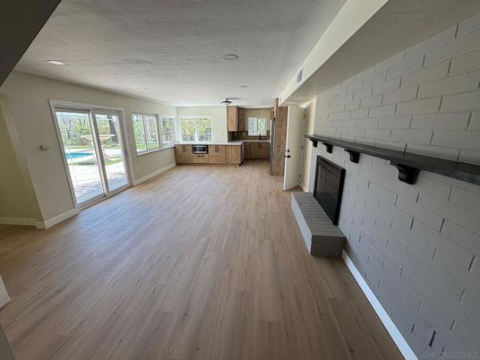 Empty room, Fireplace, Interior, Kitchen, Recessed Lighting, Stone Walls, Wood Texture Flooring