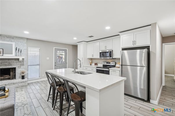 Fireplace, Interior, Kitchen, Recessed Lighting, Stainless Steel Appliances, Stone Walls, Wood Texture Flooring