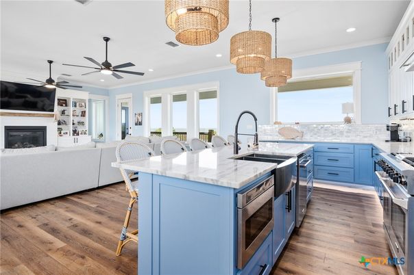 Chandelier, Fireplace, Interior, Kitchen, Living room, Pendant Lights, Recessed Lighting, Stainless Steel Appliances, Wood Texture Flooring