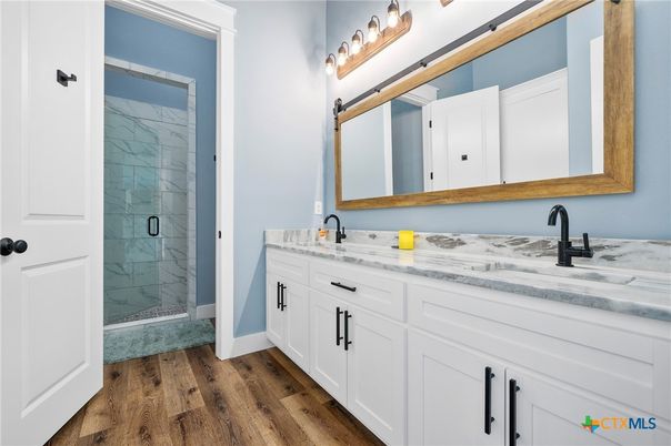 Bathroom, Dual Sink Vanities, Glass Shower, Interior, Marble Walls, Wood Texture Flooring