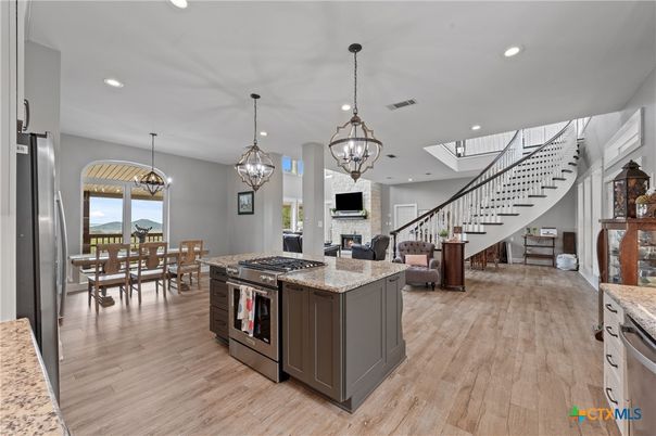Chandelier, Dining room, Fireplace, Interior, Kitchen, Living room, Pendant Lights, Recessed Lighting, Stainless Steel Appliances, Wood Texture Flooring