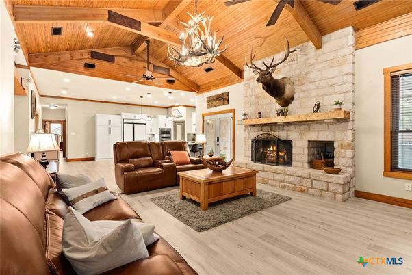 Chandelier, Fireplace, Interior, Kitchen, Living room, Pendant Lights, Recessed Lighting, Stainless Steel Appliances, Stone Walls, Wooden Beams, Wooden Ceilings, Wood Texture Flooring