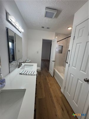 Bathroom, Dual Sink Vanities, Glass Shower, Interior, Marble Walls, Wood Texture Flooring