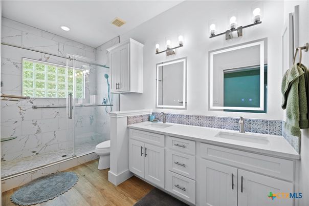 Bathroom, Dual Sink Vanities, Glass Shower, Interior, Marble Walls, Recessed Lighting, Wood Texture Flooring